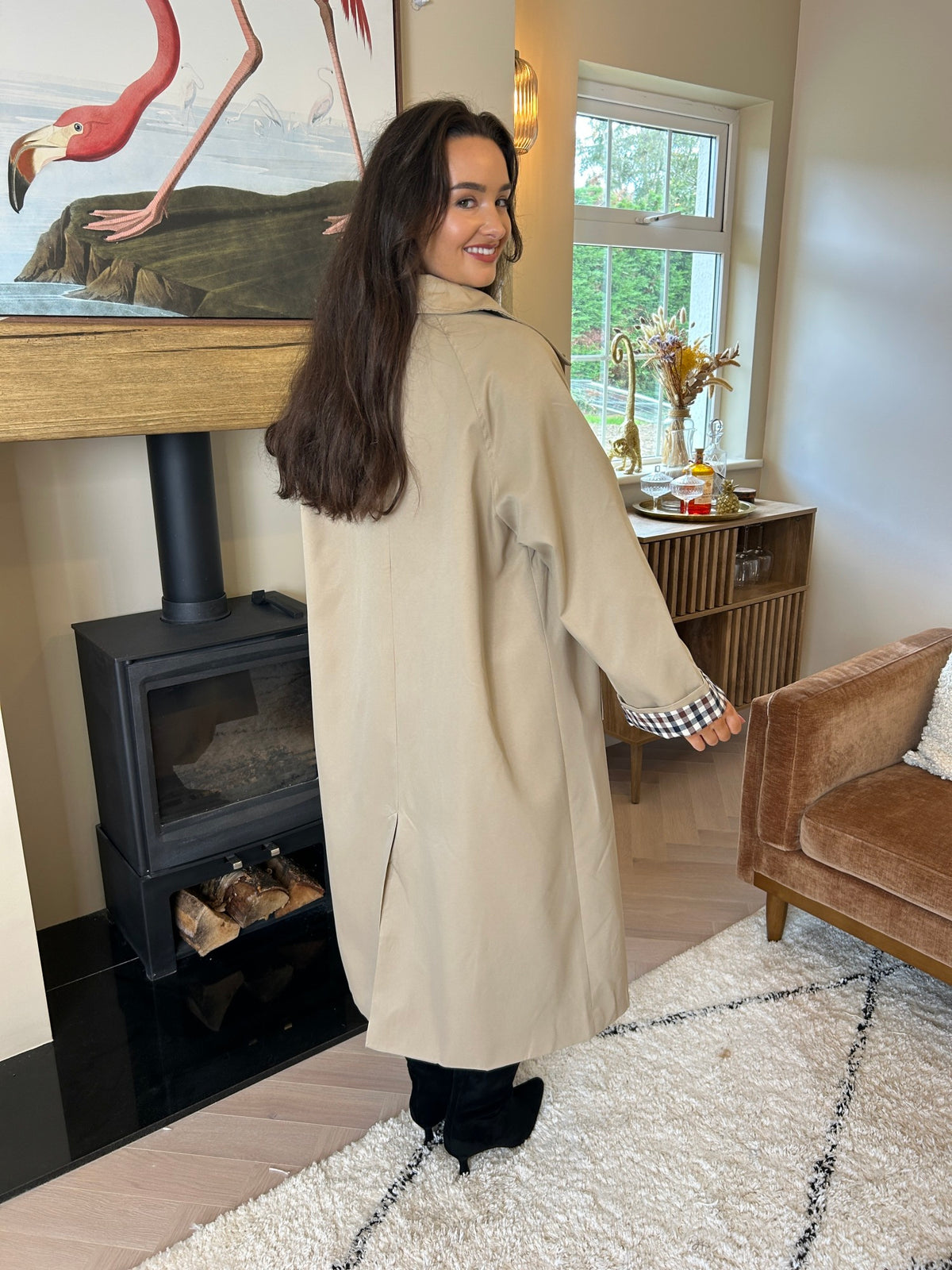 Taupe trench coat shown from the back, with a check-pattern cuff visible on the sleeve.